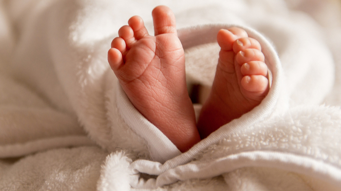 Infant feet wrapped in blanket emulating a heart shape