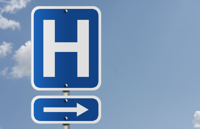 Blue letter H road sign, for hospital, with an arrow pointing to the right