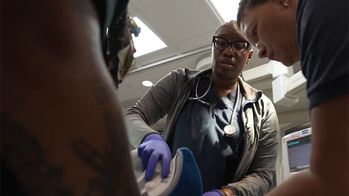 Rachel working with two other colleagues on a patient