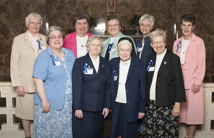 Nine Sisters stand in a group for their portrait