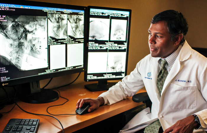 Imaging doctor sits at computer to review imaging results