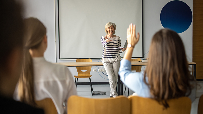 woman calling on student with hand raised