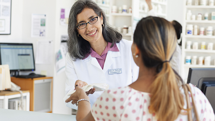 Woman at pharmacy counter with pharmacist