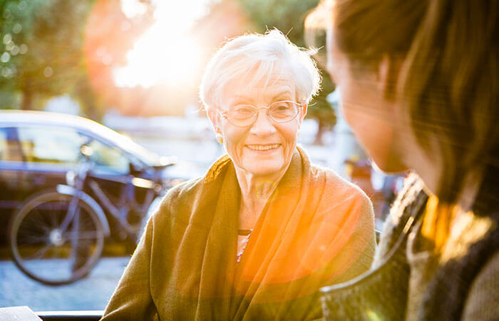 Older women smiling at younger women while the sun sets in the background