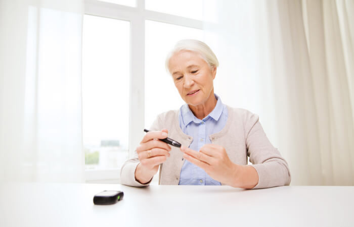 Elderly woman checking her blood sugar