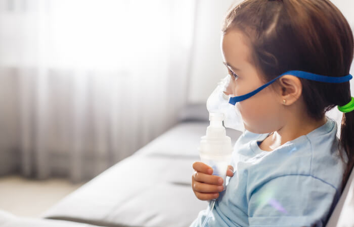 young girl receiving oxygen treatment from mask