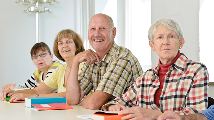 Three women and a man at a conference table