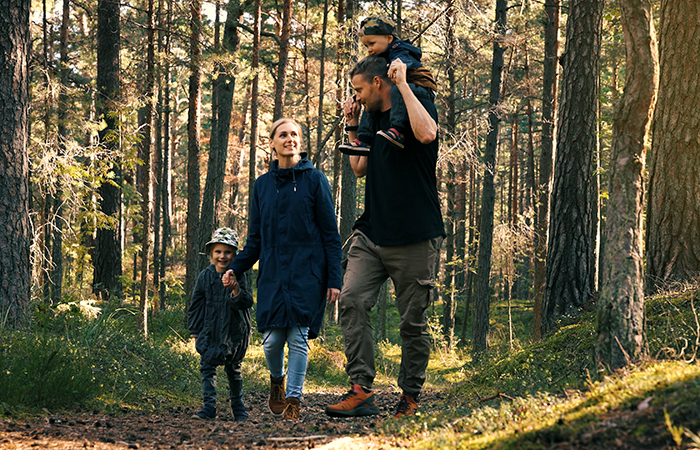 Young family walking on trail in woods