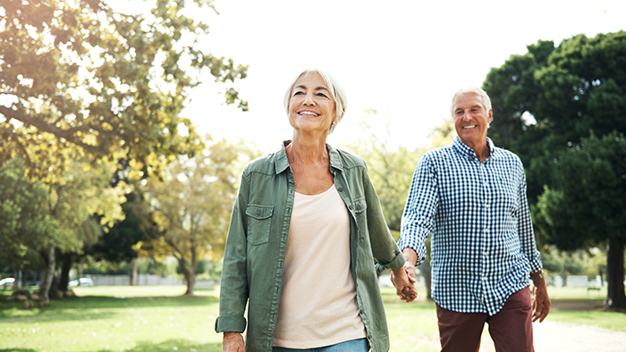 Older couple walking holding hands