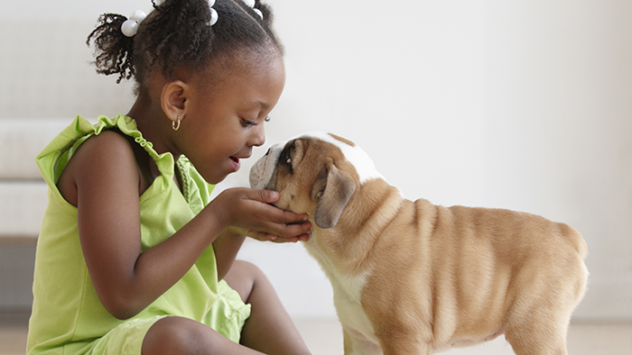 Young girl with puppy giving it a kiss