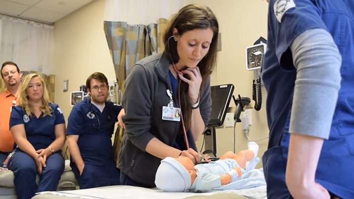 Student nurse working on simulation infant doll