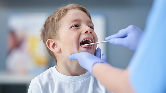 Young boy with doctor looking at his throat