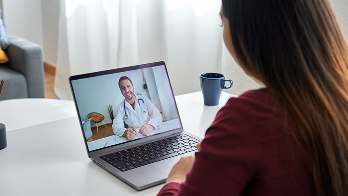 Woman receiving telemedicine from a provider on laptop