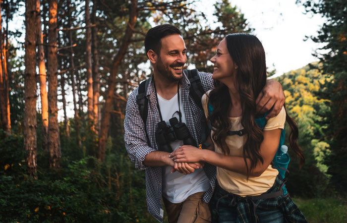 young couple walking through the woods one man and one woman