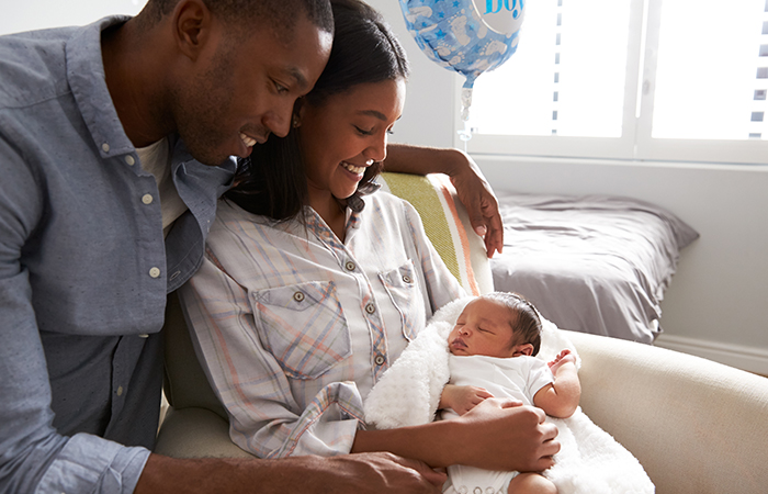 African American mother and father look at their new born baby