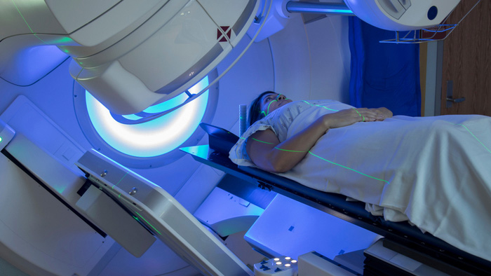 Woman in blue light on CT Scan table