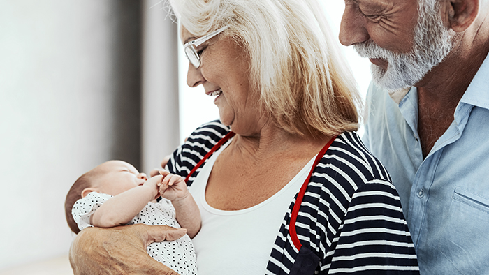 New grandma and grandpa holding infant baby girl