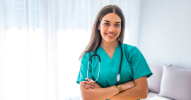 hispanic woman standing in hospital rooms looking at camera with arms crossed