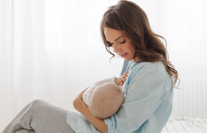 Woman holding baby while breastfeeding