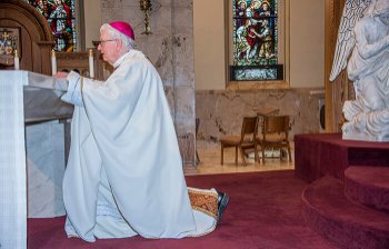 Rickens kneels before altar in chapel