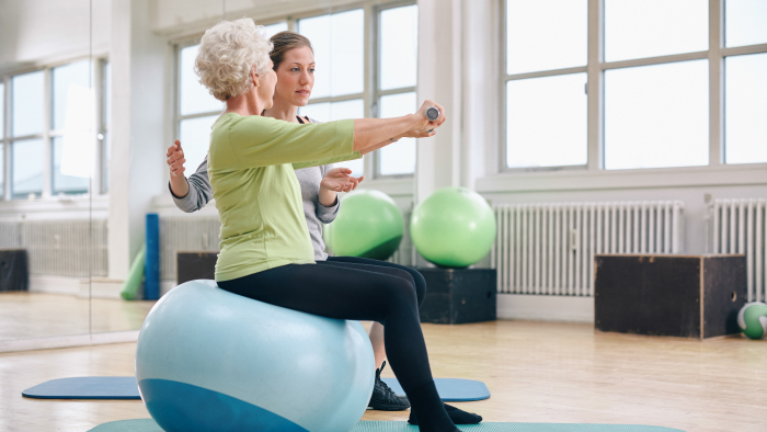Woman on balance ball receiving therapy
