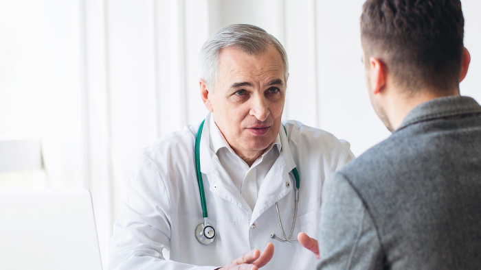 Male doctor consulting with male patient