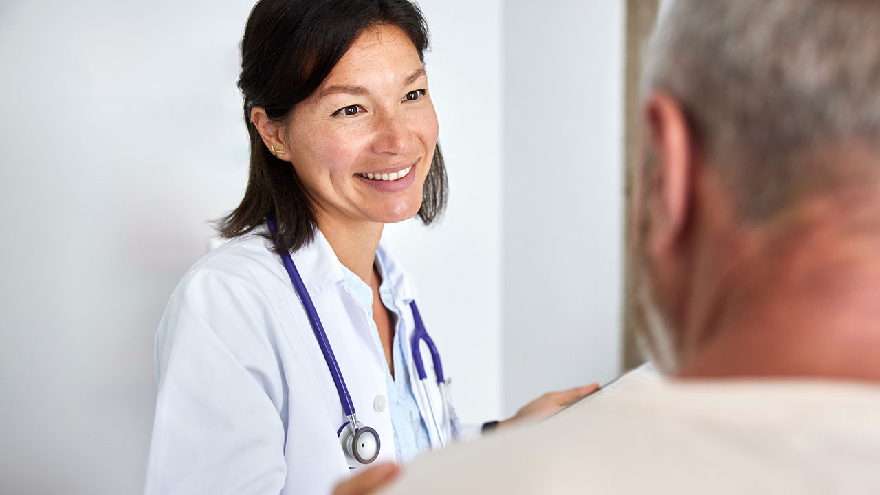 Female doctor wearing a white lab coat with a male patient