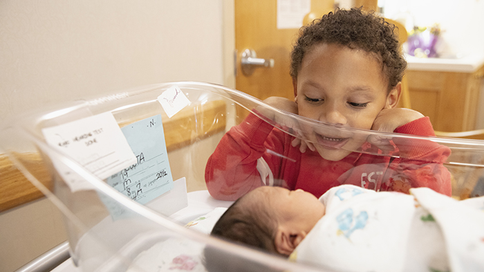 New brother looking over new baby brother