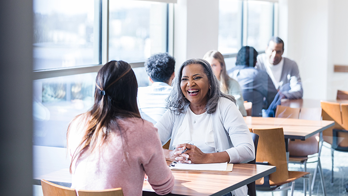 two women talking at a table
