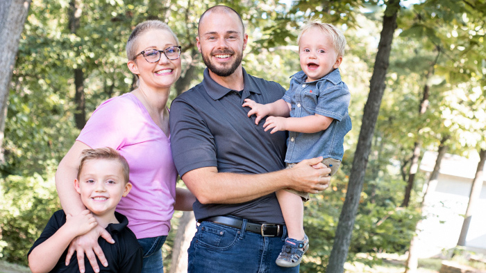 Young woman dressed in pink with her young family