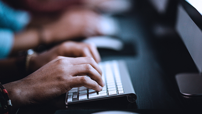 Hands working on a computer keyboard