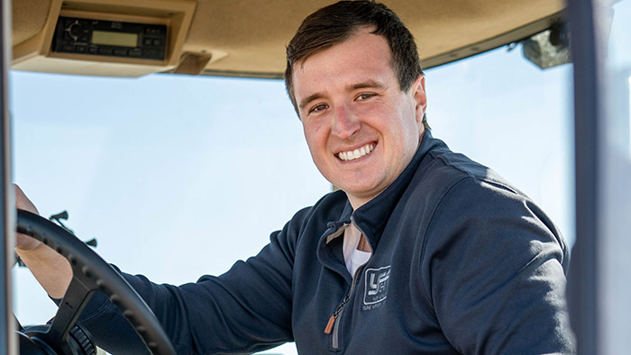 Young male farmer in the cab of a tractor