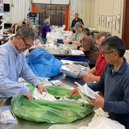 Volunteers sort through bags of donations to organize them and prep them for redistribution.