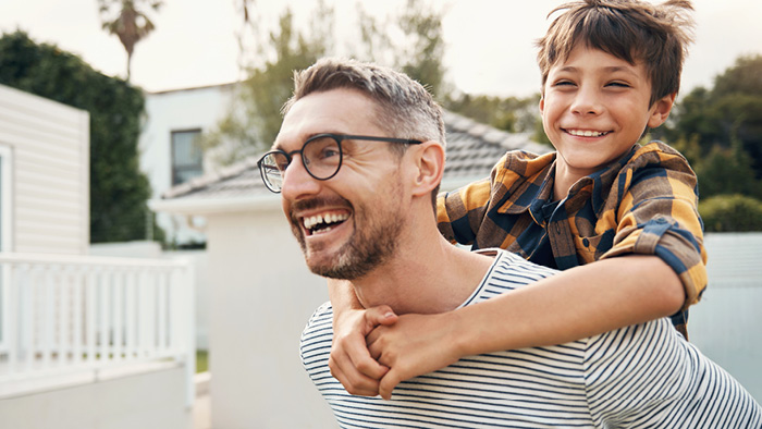 father holding son on back