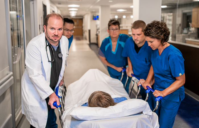 Group of doctors rushing a patient on a gurnee into care 