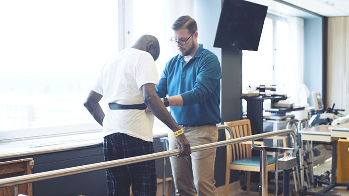 Physical Therapy professional assisting a male patient