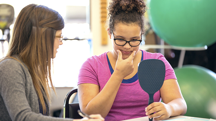 Young woman patient working with speech therapist