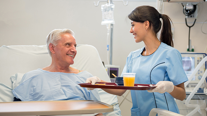 Dietitian bringing male patient a food tray