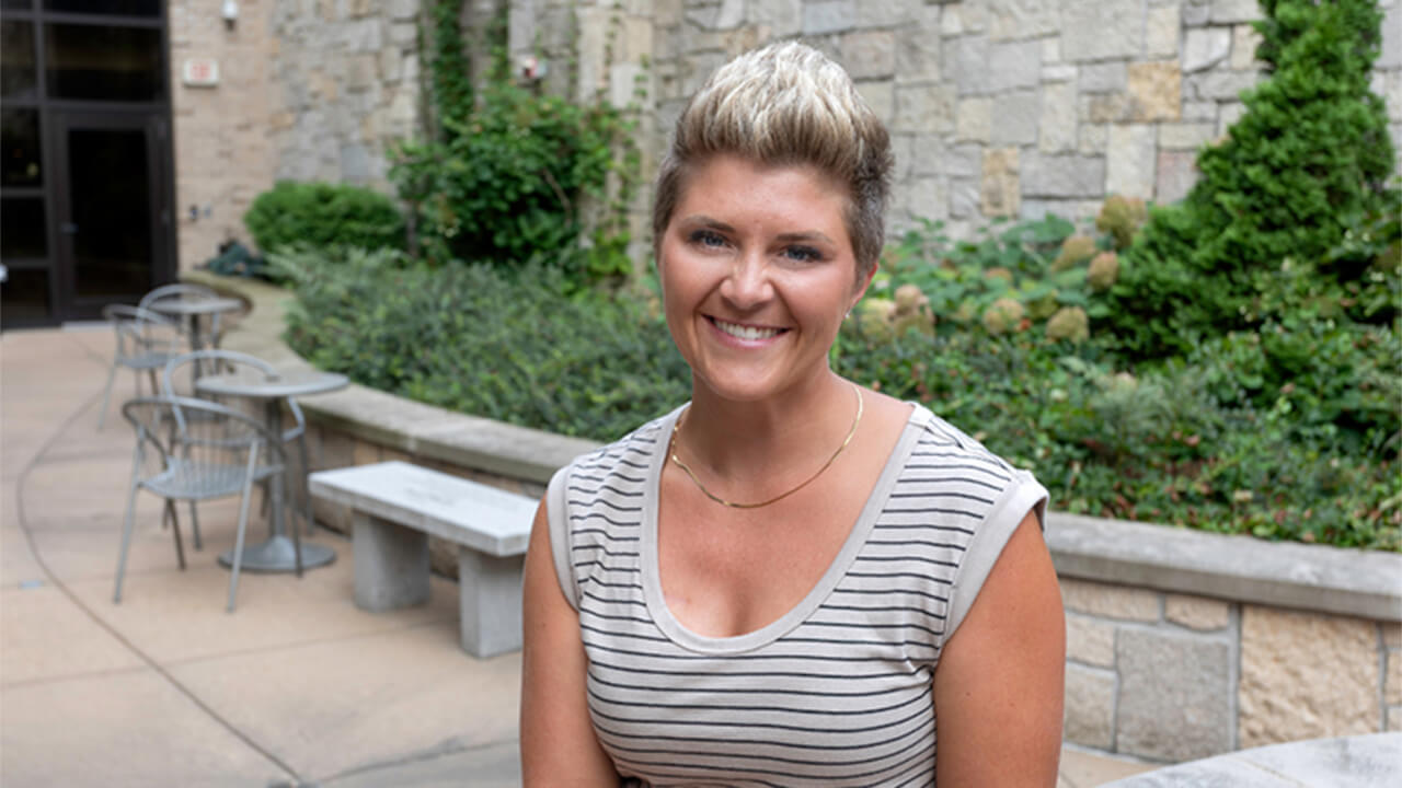Amelia sitting in front of HSHS St. Vincent Hospital's garden