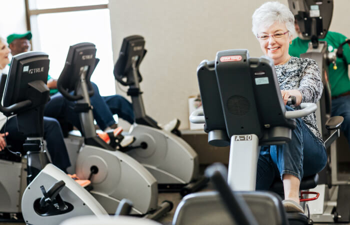older woman using recumbent bike in a therapy building
