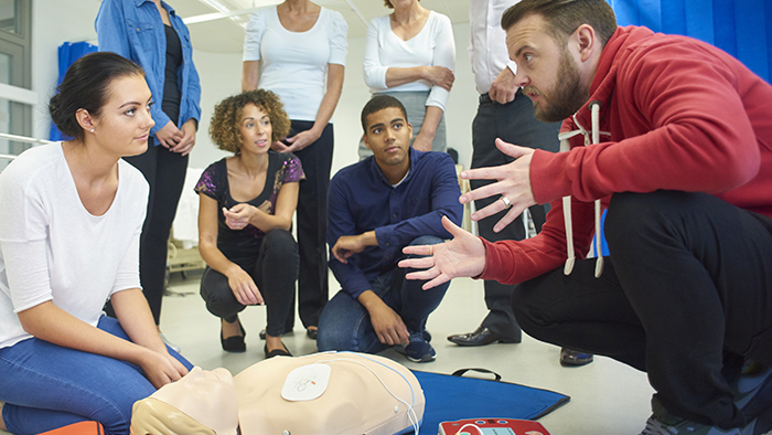 Instructor and students with CPR maniquin