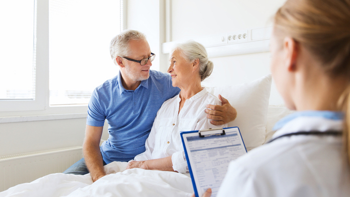 Husband with wife consulting with a nurse