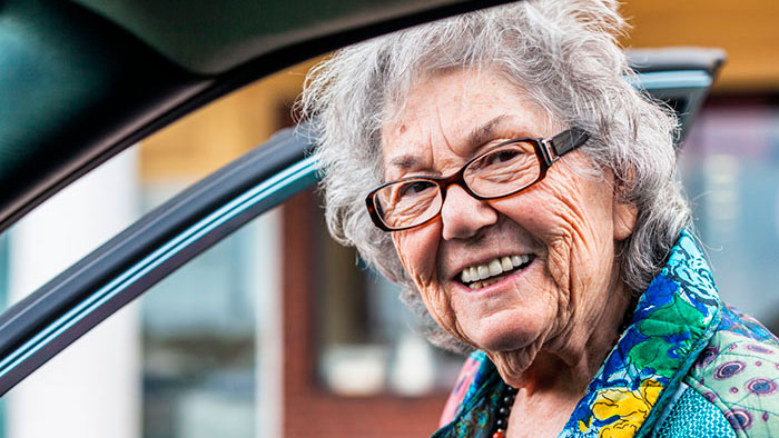 Senior woman getting into car