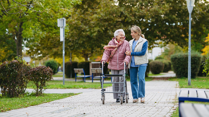 Caregiver with patient walking outside.