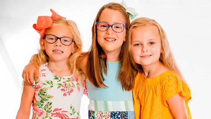 Three young girls with arms around each other