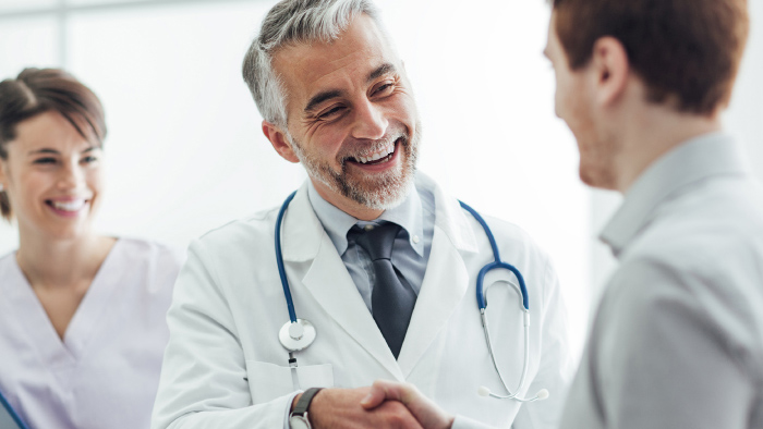 Male doctor shaking hands with male patient