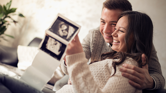 Young couple looking at baby sonogram
