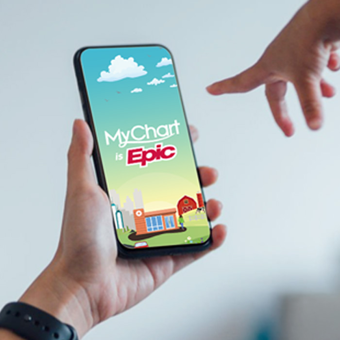Hands hold a phone with MyChart displayed on it