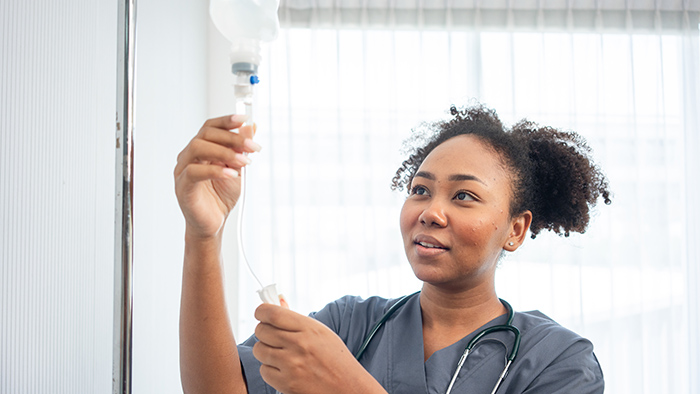 Young nurse adjusting IV