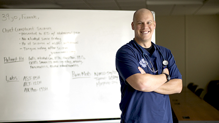 Young male nursing student in front of classroom whiteboard